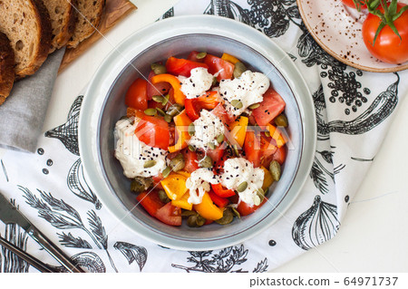 Healthy salad with grilled pepper, tomatoes, stracciatella, herbs and pumpkin seeds. Healthy eating concept. Healthy salad with grilled pepper, tomatoes, stracciatella, herbs and pumpkin seeds. Healthy eating concept. 64971737