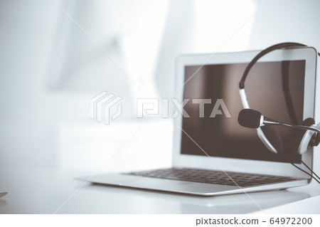 Call center and communication support, customer service help desk. VOIP headset on laptop computer Call center and communication support, customer service help desk. VOIP headset on laptop computer 64972200