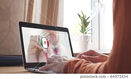 Doctor's video call on the laptop at home, stethoscope bell with the Mexican flag. Telemedicine in Mexico 64973834