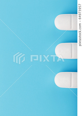 Medicinal tablets in a row on a blue background, Medicinal tablets in a row on a blue background, 64973957