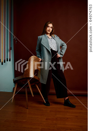 Gorgeous young female in classic suit, black shoes Gorgeous young female in classic suit, black shoes 64974763
