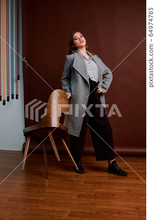 Gorgeous young female in classic suit, black shoes Gorgeous young female in classic suit, black shoes 64974765