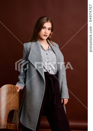 Gorgeous young female in classic suit, black shoes Gorgeous young female in classic suit, black shoes 64974767