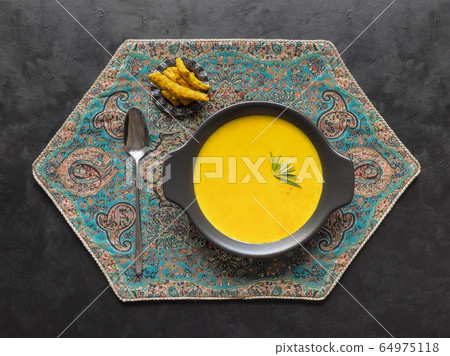 Healthy curcuma cream soup on black background 64975118