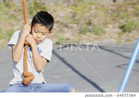 Elementary school student (4th grader) playing with Tarzan rope 64975364