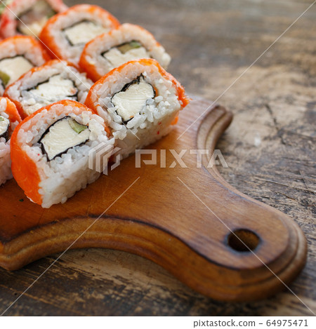 Sushi roll with salmon, avocado and cheese on 64975471
