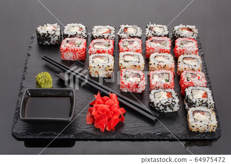 Japanese restaurant, sushi roll on black slate. Japanese restaurant, sushi roll on black slate. 64975472