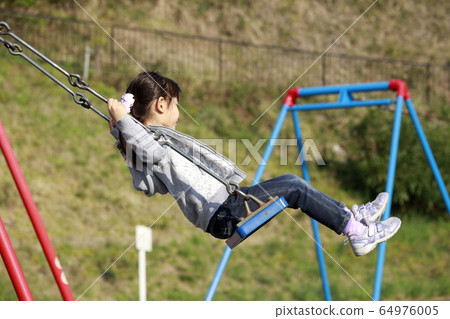 Infant playing on a swing (5-year-old) 64976005