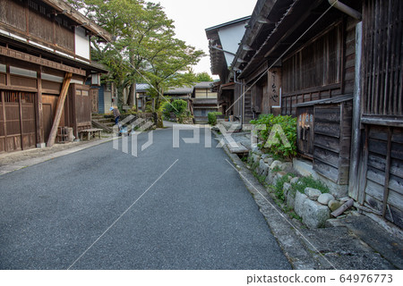 長野縣長木曾町Tsumagojuku，一位老太太正在清洗遊客諮詢中心的正面 64976773