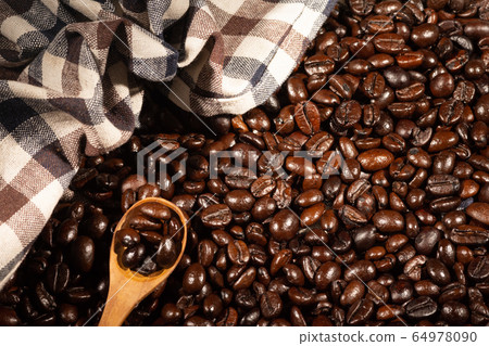 Coffee beans on brown linen fabric background.Roasted coffee beans on a wooden spoon Coffee beans on brown linen fabric background.Roasted coffee beans on a wooden spoon 64978090