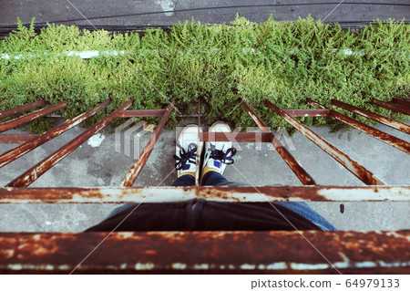 Woman stand nestle close rust handrail of balcony in stress and fearful by violence, deadlock in life Woman stand nestle close rust handrail of balcony in stress and fearful by violence, deadlock in life 64979133