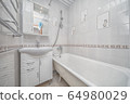 Small white tile bathroom with bath tube 64980029
