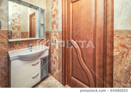 Small beige tile bathroom with sink and mirror Small beige tile bathroom with sink and mirror 64980083