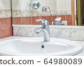 Simple cheap Faucet in bathroom white sink 64980089