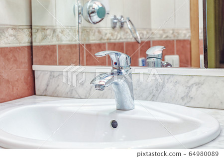 Simple cheap Faucet in bathroom white sink Simple cheap Faucet in bathroom white sink 64980089