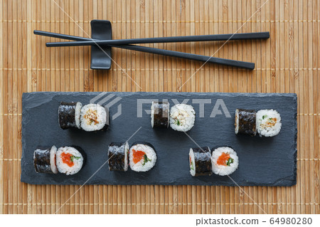 Sushi on a black stone board. Fresh sushi set with Sushi on a black stone board. Fresh sushi set with 64980280