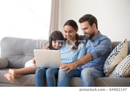 Happy family with kid daughter enjoy using laptop at home 64982147