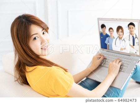 young woman  Video chatting With medical group On 64982473