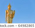 The standing buddha statue on blue sky, located in Chanthaburi, Thailand. 64982865