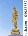 The standing buddha statue on blue sky, located in Chanthaburi, Thailand. 64982867