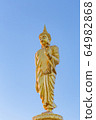 The standing buddha statue on blue sky, located in Chanthaburi, Thailand. 64982868