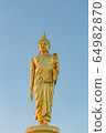The standing buddha statue on blue sky, located in Chanthaburi, Thailand. 64982870