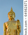 The standing buddha statue on blue sky, located in Chanthaburi, Thailand. 64982871