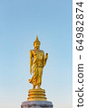 The standing buddha statue on blue sky, located in Chanthaburi, Thailand. 64982874