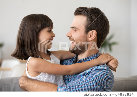 Cute kid girl laughing embracing father having fun with dad Cute kid girl laughing embracing father having fun with dad 64982934