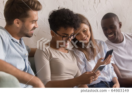 Happy diverse young people using social media apps on phones Happy diverse young people using social media apps on phones 64983149