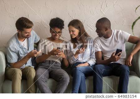Happy diverse friends group sharing social media news holding phones 64983154