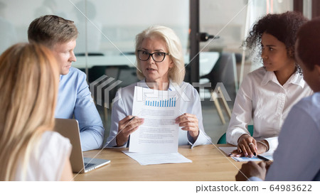 Older company executive presenting financial report result at team meeting Older company executive presenting financial report result at team meeting 64983622