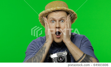 Portrait of young man tourist photographer looking shocked. Chroma key 64983806