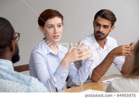 Confident female leader speak at group training explain corporate strategy Confident female leader speak at group training explain corporate strategy 64983978