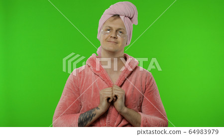 Portrait of transsexual man in bathrobe with eye patches. Chroma key 64983979