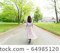 Woman walking in spring park 64985120