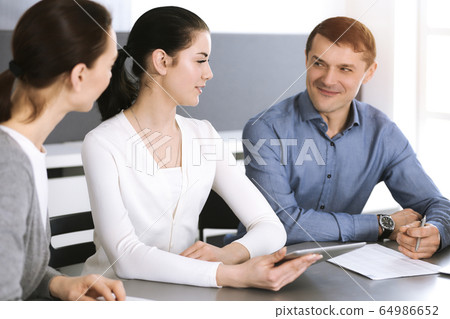 Group of business people discussing questions at meeting in modern office. Headshot at negotiation or workplace. Teamwork, partnership and business concept 64986652