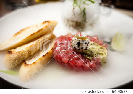 Tuna tartare served on a plate in restaurant Tuna tartare served on a plate in restaurant 64986873