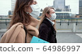 Epidemic control social workers. Two young Caucasian female doctors in face masks walk on city street during quarantine. 64986997