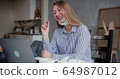 Young beautiful happy blonde woman using laptop to chat with friends on video call from home with her face mask off. 64987012
