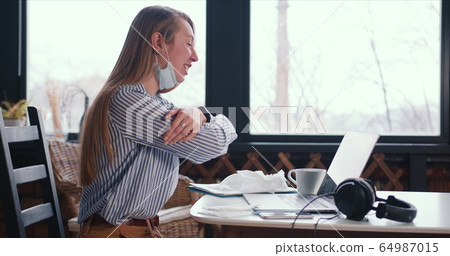 Side view young healthy happy woman making video call on laptop to chat with friends from home with face mask on neck. Side view young healthy happy woman making video call on laptop to chat with friends from home with face mask on neck. 64987015