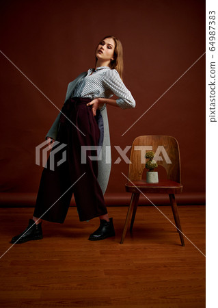 Gorgeous young female in classic suit, black shoes 64987383