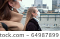 Epidemic control social workers. Two young Caucasian female doctors in face masks walk on city street during quarantine. 64987899