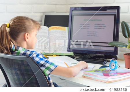 Girl doing homework on the computer at home Girl doing homework on the computer at home 64988286