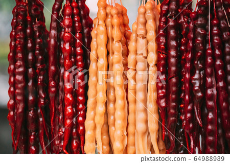 Churchkhela Hanging In Shop. Churchkhela Is A Traditional Georgian Food Sausage-shaped Candy. Main Ingredients Are Grape Must, Nuts And Flour 64988989