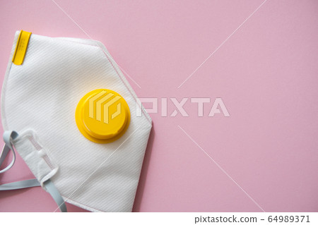 Respirator mask FFP or dust mask to cover the mouth and nose prevent coronavirus isolated on pink background. Breathing protection against air pollution, flu and coronavirus. 64989371