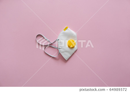 Respirator mask FFP or dust mask to cover the mouth and nose prevent coronavirus isolated on pink background. Breathing protection against air pollution, flu and coronavirus. Respirator mask FFP or dust mask to cover the mouth and nose prevent coronavirus isolated on pink background. Breathing protection against air pollution, flu and coronavirus. 64989372