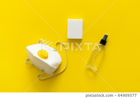 Protective mask, respirator ffp, soap and antiseptic lie on a yellow background. Anti-virus protection kit against covid-19. Coronavirus pandemic 2019. Protective mask, respirator ffp, soap and antiseptic lie on a yellow background. Anti-virus protection kit against covid-19. Coronavirus pandemic 2019. 64989377