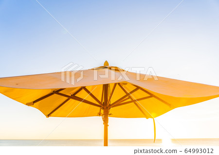 Beautiful tropical nature umbrella chair with palm tree around beach sea ocean at sunset or sunrise Beautiful tropical nature umbrella chair with palm tree around beach sea ocean at sunset or sunrise 64993012