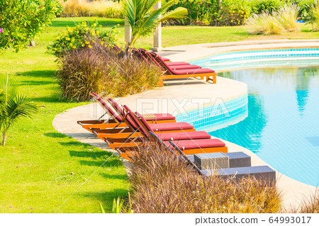 Beautiful empty chair around outdoor swimming pool in hotel resort Beautiful empty chair around outdoor swimming pool in hotel resort 64993017